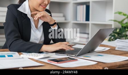 Asiatische Frau arbeitet Laptop. Geschäftsfrau beschäftigt mit der Arbeit am Laptop im Büro Stockfoto