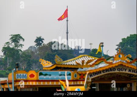 Der Flaggenturm der Zitadelle mit verschwommenen (unscharfen) Details eines Drachenschiffes im Vordergrund in Hue, Vietnam. Stockfoto