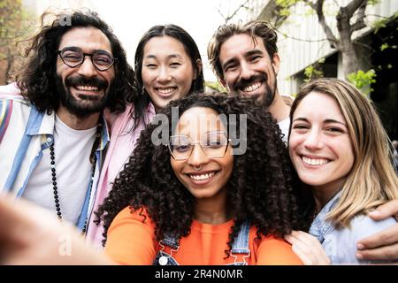 Vielfältige Gruppe von Freunden, die ein Selfie auf der Straße machen. Fröhliche multiethnische Gruppe von jungen Hipstern, die ein Foto machen und in die Kamera schauen. Stockfoto