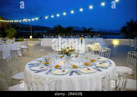 Elegante Banketttische im Außencafé am Abend Stockfoto