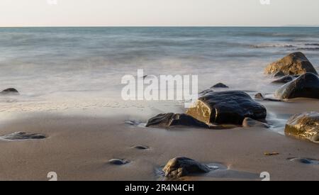 Küste mit Felsen und seidenem Wassereffekt, Hintergrund. Stockfoto
