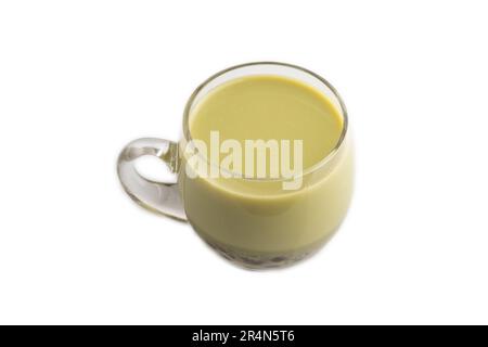 Seifenblasentee mit Pistazien und Karamell in Glas, isoliert auf weißem Hintergrund. Das Konzept des gesunden Getränks. Seitenansicht, Nahaufnahme. Stockfoto