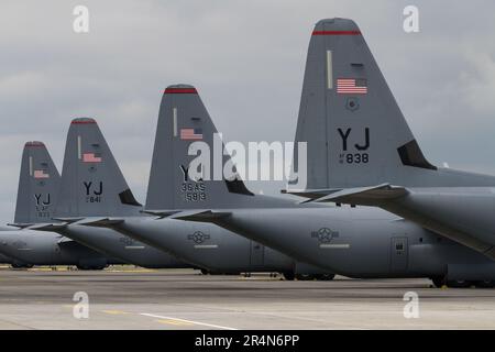 Die Heckflossen einer US-Luftwaffenlinie (USAF) Lockheed Martin C130-J Hercules transportieren Flugzeuge auf dem Yokota-Stützpunkt in Fussa, Tokio, Japan. Stockfoto