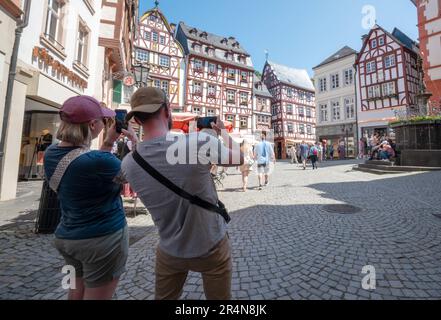 Bernkastel Kues, Deutschland. 29. Mai 2023. Ein Paar aus Belgien, das während seines Besuchs Fotos von den Fachwerkhäusern der historischen Altstadt macht. Kredit: Harald Tittel/dpa/Alamy Live News Stockfoto