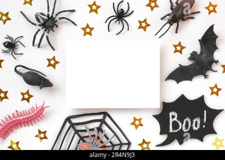 Weißes Blatt zu Halloween mit schwarzen Fledermäusen, Spinnen und goldenen Sternen. Modernes Weihnachtsmodell. Halloween-Party-Einladung. Flach liegend, oben Stockfoto