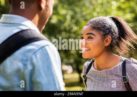 afroamerikanische Freunde teilen ihr Wissen auf dem Universitätscampus an sonnigen Tagen im Park Stockfoto
