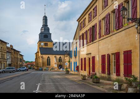 Die Straße „Grande Rue“ und die Kirche sind „église Saint-Nicolas“ von Marville im Nordosten Frankreichs Stockfoto