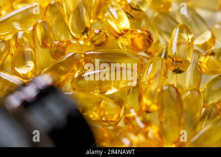 Gelbe Omega 3 Kapseln mit einer Flasche. Verstreute natürliche Meeresfische-Ergänzung. Schließen Stockfoto