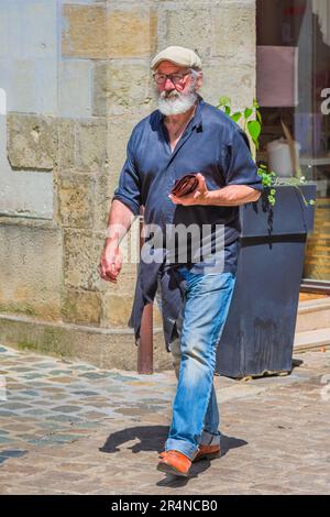 Lässig gekleideter bärtiger Mann, der auf der Straße der Stadt spaziert - Loches, Indre-et-Loire (37), Frankreich. Stockfoto