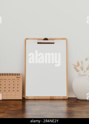 Holzklipp mit leerem Papier mit Kopierbereich auf weißem Hintergrund und Dekoration. Minimalkonzept. Werbetafel, Geschäftsvorlage. Draufsicht Stockfoto