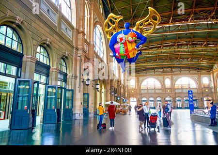 ZÜRICH, SCHWEIZ - 3. APRIL 2022: Haupthalle des Züricher Hauptbahnhofs mit farbenfroher L'ange-Protekteur-Skulptur von Niki de Saint Phalle am April Stockfoto