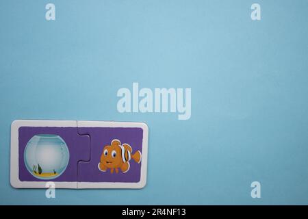 Puzzles auf blauem Hintergrund platzieren. Fisch und Aquarium. Stockfoto