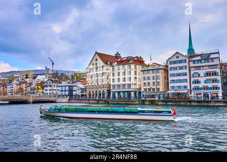 ZÜRICH, SCHWEIZ - 3. APRIL 2022: Das moderne Kanalboot fährt am 3. April in Zürich, Schweiz, auf dem Fluss Limmat im Zentrum der Stadt Stockfoto