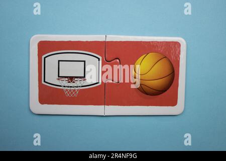 Puzzles auf blauem Hintergrund überlagern. Basketball und Basketballkorb. Stockfoto