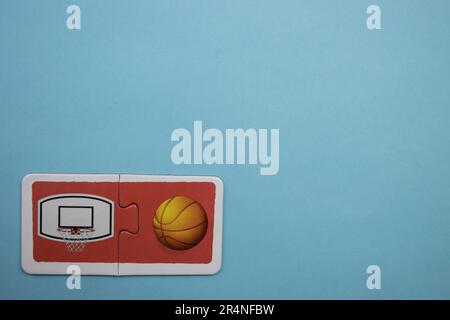 Puzzles auf dem blauen Hintergrund platzieren. Basketball und Basketballkorb. Stockfoto
