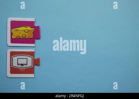 Puzzles auf dem blauen Hintergrund platzieren. Basketball, Reifen und Käse. Stockfoto