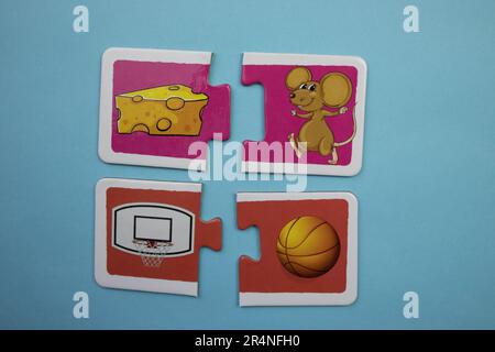 Puzzles auf blauem Hintergrund überlagern. Basketball, Basketballkorb, Maus und Käse. Stockfoto