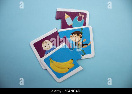 Puzzles auf blauem Hintergrund. Affe, Banane, Baby, Dinge. Gemischt. Stockfoto