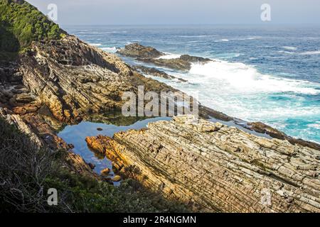 Blick auf einen ruhigen Felsenpool entlang der felsigen Küste in Garden Route, Südafrika Stockfoto