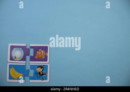 Informationspuzzles am Rand des blauen Hintergrunds. Fisch und Affe. Stockfoto