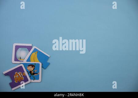 Informationspuzzles am Rand des blauen Hintergrunds. Fisch und Affe. Stockfoto
