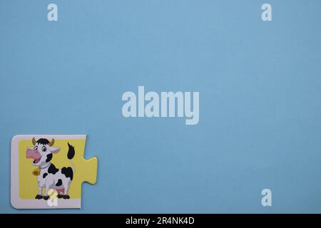 Informationspuzzles am Rand des blauen Hintergrunds. Ein Bild von einer Kuh. Stockfoto