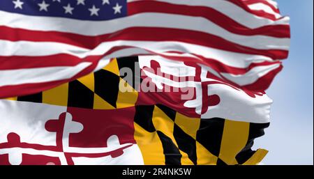 Nahaufnahme der Staatsflagge von Maryland, die im Wind winkt, mit einem verschwommenen Teil der Nationalflagge der Vereinigten Staaten im Hintergrund. Patriotisch und symbolisch Stockfoto