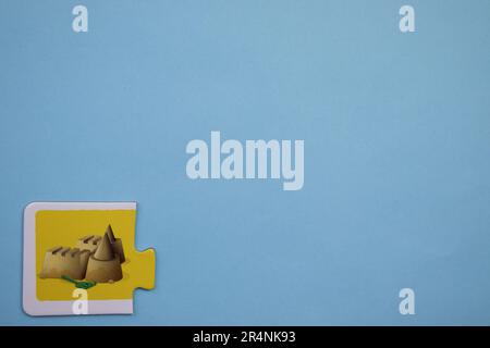 Informationspuzzles am Rand des blauen Hintergrunds. Eine Sandburg. Stockfoto