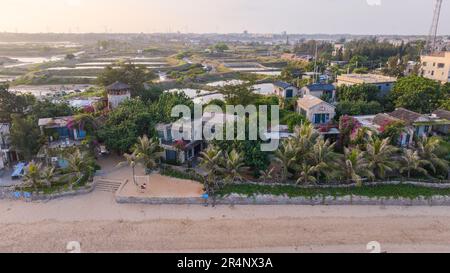 (230529) -- ZHANJIANG, 29. Mai 2023 (Xinhua) -- Dieses Luftfoto wurde am 28. Mai 2023 aufgenommen und zeigt die Aussicht auf Homestays in der Stadt Jiaowei im Bezirk Xuwen, der Stadt Zhanjiang, Südchina Provinz Guangdong. An der östlichen Grenze zum Südchinesischen Meer und im Westen zum Beibu-Golf und südlich gegenüber der Insel Hainan über die Straße von Qiongzhou, Die Stadt Zhanjiang in der südchinesischen Provinz Guangdong verfügt über die größte Fläche an Mangrovenwäldern im ganzen Land und ist eine wichtige Basis für Wasserprodukte. In den letzten Jahren hat die Stadt großen Wert auf die Entwicklung grüner Industrien und der marinen eg gelegt Stockfoto