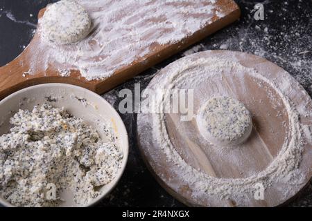 Fotoplatte mit einer Mischung aus Hüttenkäse, Eiern, Mehl und Zucker, auf einem Holzbrett gibt es einen Hüttenkäsekuchen im Mehl Stockfoto