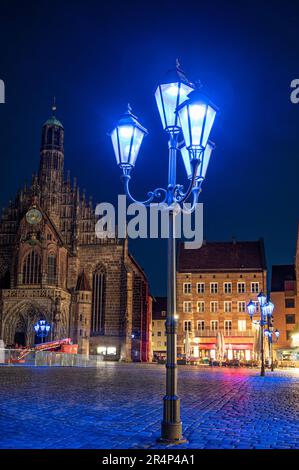 Blaue Straßenlaternen vor der Frauenkirche in Nürnberg. Die blaue Nacht 2023. Stockfoto