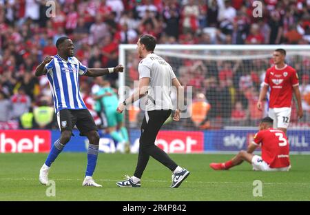 Dominic Iorfa (links) vom Sheffield Wednesday feiert den Sieg und die Beförderung zur Sky Bet Championship, da Jonathan Russell und Bobby Thomas (rechts) von Barnsley nach dem Sky Bet League One Play-Off-Finale im Wembley Stadium, London, dejected wirken. Foto: Montag, 29. Mai 2023. Stockfoto