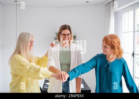 Eine Gruppe von Frauen, die sich an Hand und mit Kräften zusammentun, um ein starkes Unternehmen zu schaffen. Konzept: Unternehmen, Start-up, befähigte Frauen Stockfoto