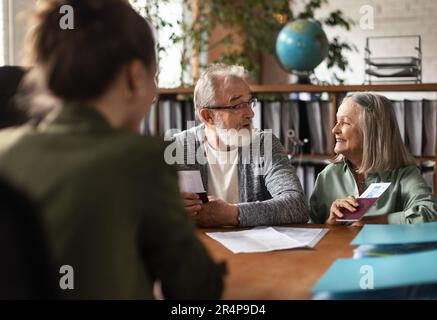 Nahaufnahme eines Seniorenpaares im Reisebüro, das Flugtickets kauft. Stockfoto