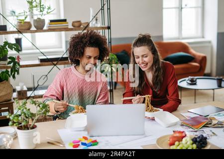 Junge Kollegen, die in ihrem Büro zu Mittag essen. Stockfoto