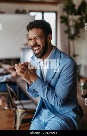 Portrait eines glücklichen, aufgeregten jungen Geschäftsmannes nach Abschluss eines Geschäftsabschlusses. Stockfoto