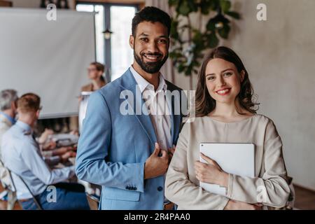 Portrait von selbstbewussten jungen Kollegen während des Teammeetings. Stockfoto