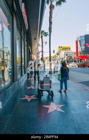 Hollywood, Kalifornien, USA - 26. April 2023. Roboterlieferung in West Hollywood. Der Server-Roboter fährt sich selbst den Bürgersteig hinunter, während er Essen macht Stockfoto