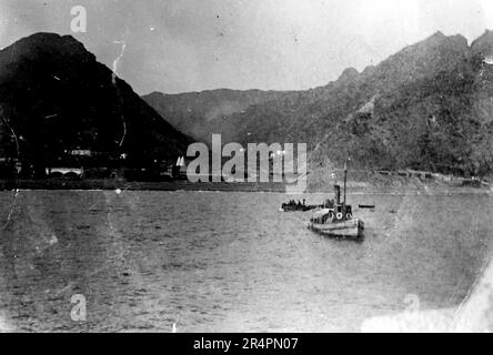 Südindien, von denen Teile heute als Pakistan bekannt sind: Ein Boot, das von einer bergigen Landschaft umgeben ist. Aus einer Serie, die aus dem ursprünglichen Schnappschuss des Ersten Weltkriegs in Indien, c1917-19, aufgenommen wurde. Die Originale waren kleine Fotos, die bei zu großer Vergrößerung schlecht aussehen könnten. Stockfoto