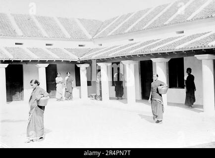 Südindien, von denen Teile heute als Pakistan bekannt sind: Innenhof im Wohnhaus mit Zimmern an den Rändern. Palamathi. Das Mädchen auf der linken Seite wird Wasser in den Messingtopf ziehen, den sie trägt – sie hatte ihre beiden kleinen Kinder zuvor aufgegeben, weil ihr Mann es ablehnte, dass sie Christ sein und bei der Familie bleiben durfte, c1918. Aus einer Serie, die aus dem ursprünglichen Schnappschuss des Ersten Weltkriegs in Indien, c1917-19, aufgenommen wurde. Die Originale waren kleine Fotos, die bei zu großer Vergrößerung schlecht aussehen könnten. Stockfoto