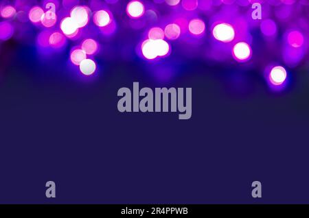 Violetter Bokeh-Effekt mit Kopierraum. Abstrakter eleganter Hintergrund für Weihnachten. Funkelnde magische Staubpartikel. Magisches Konzept. Stockfoto