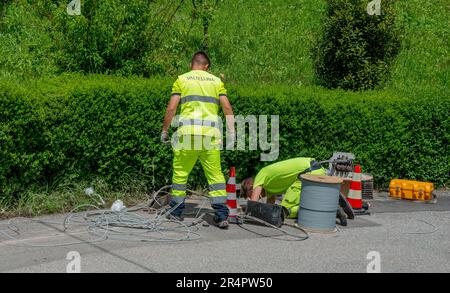 Bergamo Italien Mai 25. 2023: Arbeiter, die die Kabel für den Anschluss der Glasfaser verlegen Stockfoto