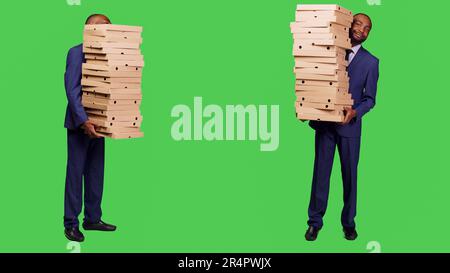 Männlicher Unternehmer mit einem großen Haufen Pizzaschachteln Stockfoto