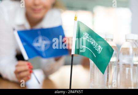 Die Ministerin legt die Flaggen der NATO und Saudi-Arabiens auf den Tisch, bevor die Verhandlungen mit hochrangigen politischen Persönlichkeiten beginnen Stockfoto