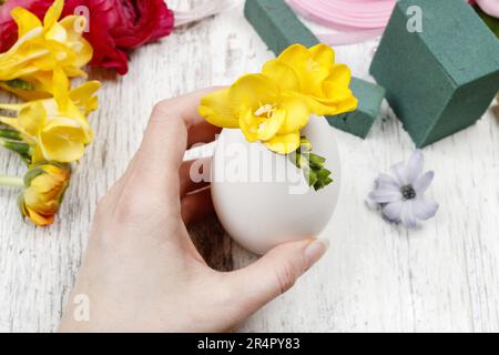 Wie man Frühlingsstrauß aus Blüten in Gänseeierschale macht - Schritt für Schritt, Anleitung. Stockfoto