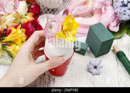 Wie man Frühlingsstrauß aus Blüten in Gänseeierschale macht - Schritt für Schritt, Anleitung. Stockfoto