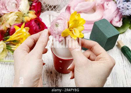 Wie man Frühlingsstrauß aus Blüten in Gänseeierschale macht - Schritt für Schritt, Anleitung. Stockfoto