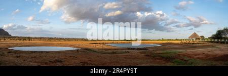 Ein Wasserloch, das die Tierwelt hinter einer Wildnis-Lodge anzieht. Kenia, Afrika. Stockfoto