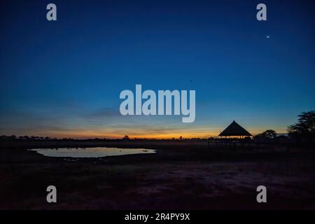 Ein Wasserloch, das die Tierwelt hinter einer Wildnis-Lodge anzieht. Kenia, Afrika. Stockfoto