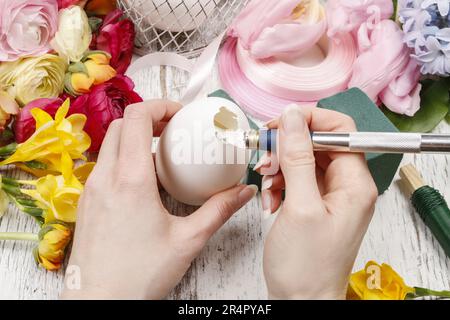 Wie man Frühlingsstrauß aus Blüten in Gänseeierschale macht - Schritt für Schritt, Anleitung. Stockfoto